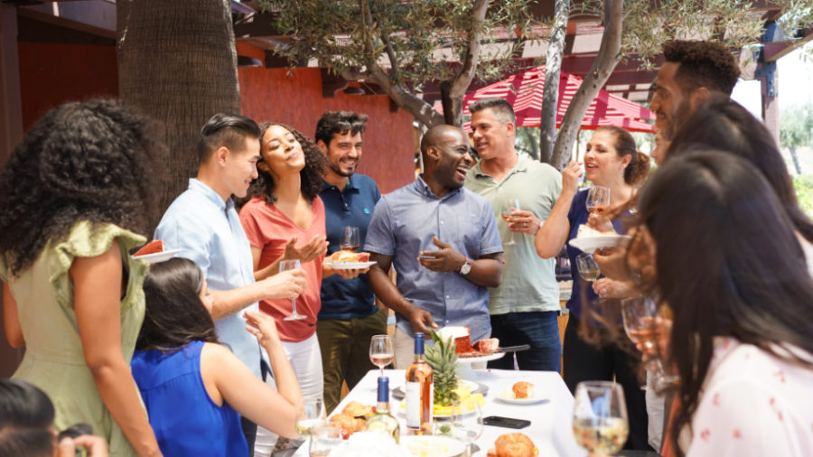 Group of diverse people enjoying wine and food